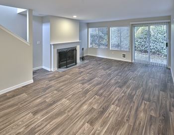 a living room with a fireplace and wooden floors at Edmonds Gateway, Edmonds, WA 98026
